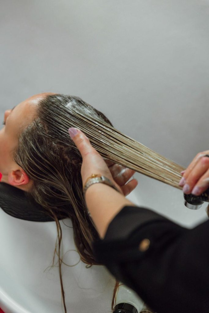 Friseurin wäscht Haare einer Kundin