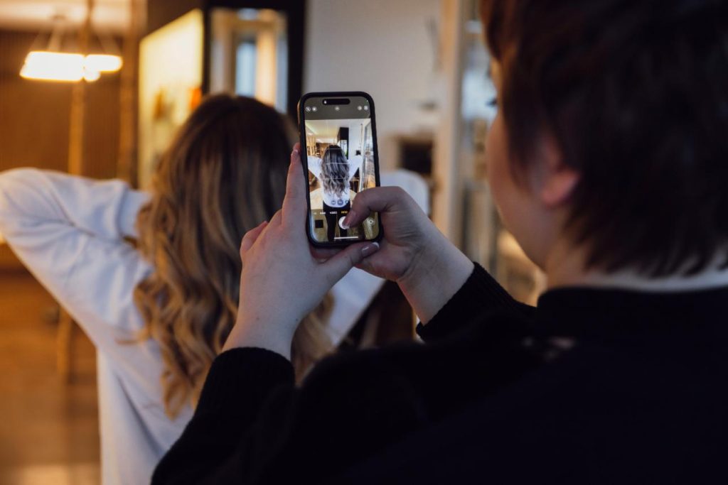 Frau fotografiert Haarschnitt einer anderen Frau