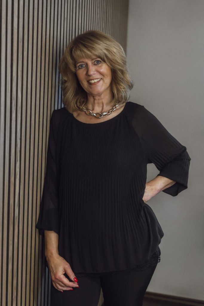 Frau steht an Wand
